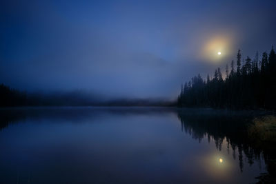 Scenic view of lake against sky at night