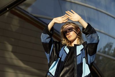 Portrait of woman gesturing against sunlight