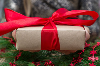 Midsection of woman holding christmas present at table