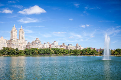 Fountain at jacqueline kennedy onassis reservoir in central park against sky