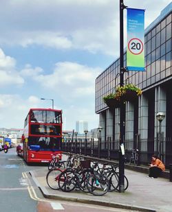 Bicycles on road against cloudy sky