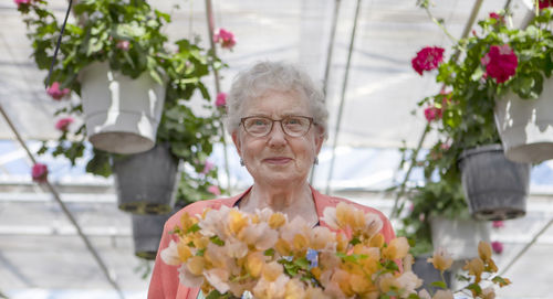 Portrait of senior woman with flowers in flower market