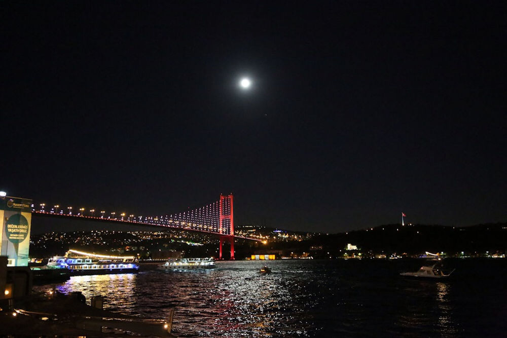 night, illuminated, connection, bridge - man made structure, water, architecture, built structure, river, waterfront, city, bridge, engineering, moon, transportation, copy space, sky, suspension bridge, clear sky, reflection, building exterior