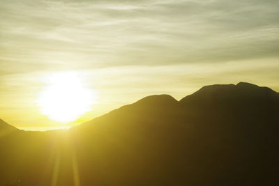 Scenic view of silhouette mountains against sky at sunset