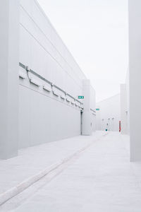 Empty road by building against clear sky