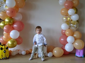 Cute little toddler celebrating birthday with balloons