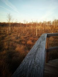 Wooden fence on field against sky