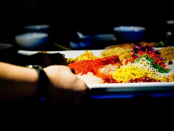 Close-up of hand holding food in plate