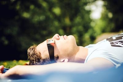 Close-up of man wearing 3-d glasses while lying on field