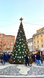 Christmas tree in city against sky