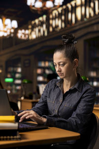 Young woman using laptop at cafe