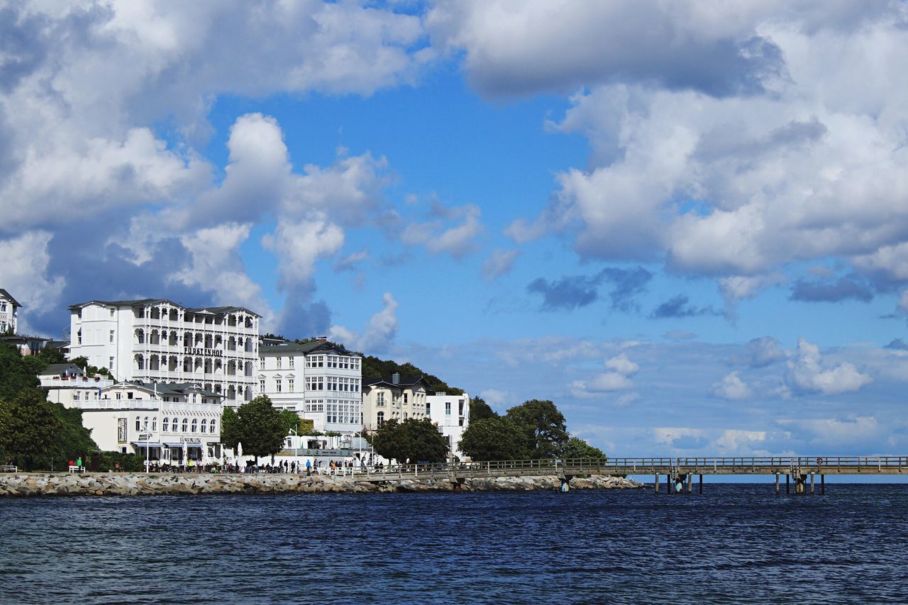 water, sea, architecture, waterfront, built structure, building exterior, sky, cloud, city, cloud - sky, scenics, day, tranquil scene, coastline, blue, tranquility, city life, outdoors, calm, cloudscape, cloudy, nature, ocean, beauty in nature, cumulus cloud, shore, residential district