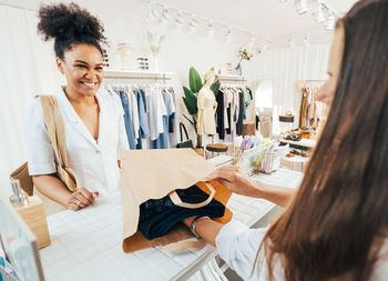 Smiling woman playing at clothing store