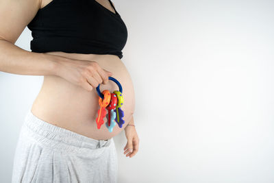 Midsection of woman standing against white background