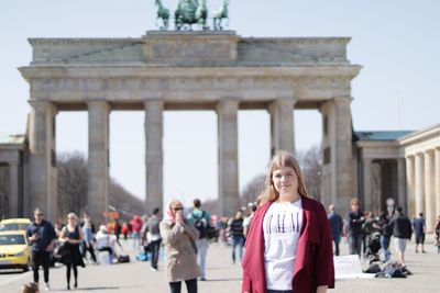 Portrait of woman standing against brandenburg gate