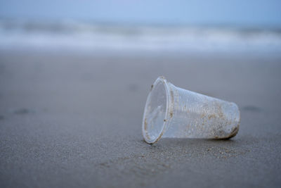 Close-up of cigarette on sand at beach