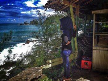 Full length of woman standing by sea against sky