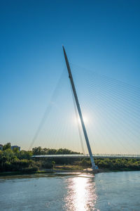 View of bridge over water against clear blue sky