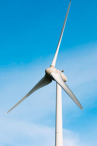 Low angle view of windmill against blue sky