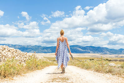 Rear view of woman looking at mountain against sky