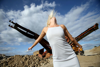 Low section of woman standing on land against sky