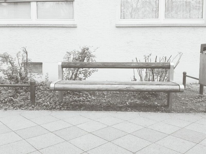 architecture, built structure, building exterior, empty, absence, chair, window, sidewalk, day, bench, cobblestone, sunlight, tiled floor, house, wall - building feature, outdoors, paving stone, no people, plant, shadow