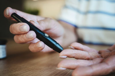 Woman puncturing finger for blood sugar test