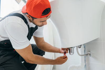 Midsection of man washing hands in sink