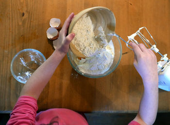 Cropped image of woman making dough 