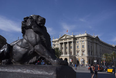 Statue in city against sky