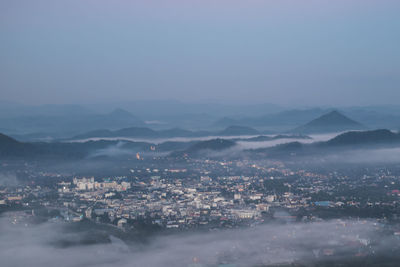 Aerial view of buildings in city against sky