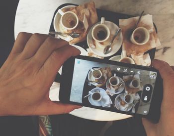 Cropped image of hand holding coffee cup