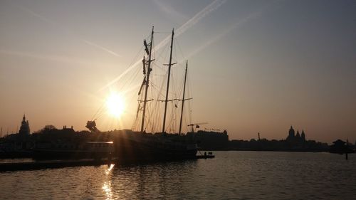 Silhouette of cranes at harbor during sunset