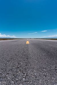 Surface level of road against blue sky