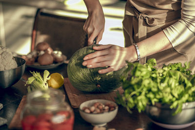 Hands of young woman cuts pumpkin. cooking a vegan lunch. concept of healthy nutrition