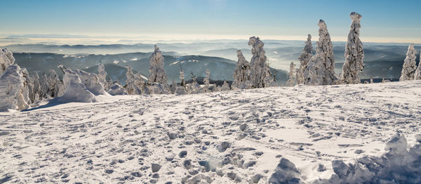 Snow covered landscape against sky