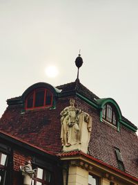 Low angle view of statue against building against clear sky