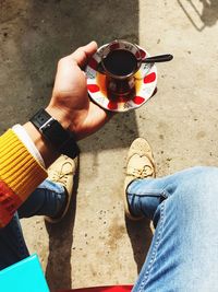 Low section of man holding coffee