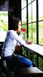 Side view of woman sitting on chair