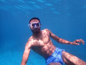 Portrait of shirtless man in sea