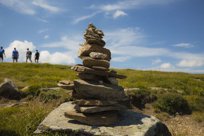 Stack of rocks on field against sky