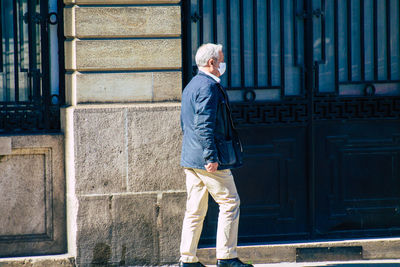 Full length of man standing against building