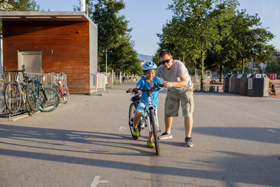Rear view of man riding bicycle on street