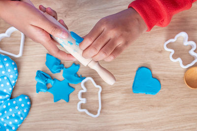 Cropped hands of girl playing with play clay on table