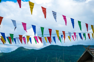 Low angle view of bunting flags against sky