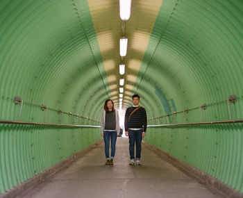 Full length of man and woman standing in tunnel