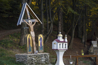 Cross amidst trees in forest