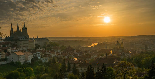 Scenic view of town by buildings against sky during sunset