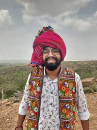 Portrait of young man standing against sky