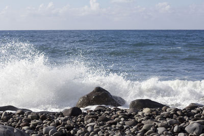 Scenic view of sea waves splashing on rocks